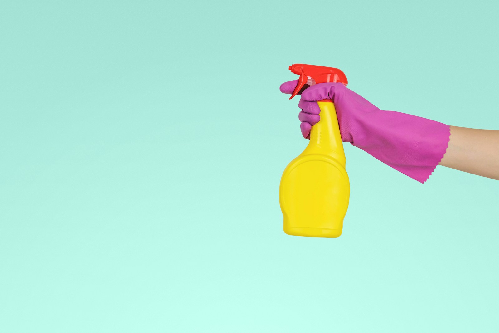 Photo by JESHOOTS.COM person holding yellow plastic spray bottle